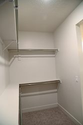 A small, empty closet with a metal rod and shelf.