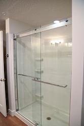 A white bathroom with a glass shower door.