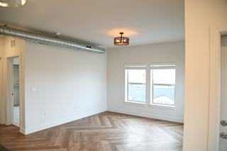 Empty living room with wood floors and ceiling light at The Revival Apartments, Salt Lake City, UT 84101