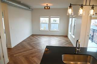 Open living room with kitchen island and pendant lights at The Revival Apartments, Salt Lake City, Utah