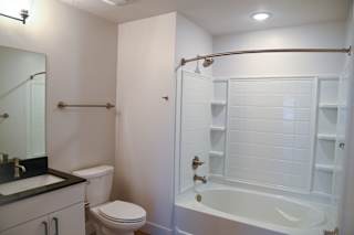 Bathroom with white tub surround and storage niches at The Revival Apartments, Salt Lake City, UT 84101