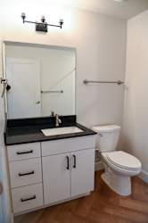 Bathroom vanity with black countertop and towel bar at The Revival Apartments, Salt Lake City, 84101