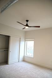 Empty bedroom with ceiling fan and closet at The Revival Apartments, Utah