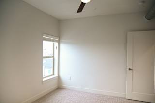 Empty bedroom with window and ceiling fan at The Revival Apartments, Utah, 84101