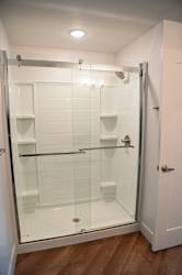 Walk in shower with sliding glass door and built in shelves at The Revival Apartments, Salt Lake City, UT 84101