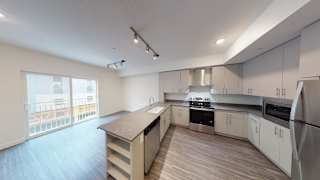 A modern kitchen with white cabinets and a wooden floor. at Paperbox Lofts Apartments, Salt Lake City  , 84101