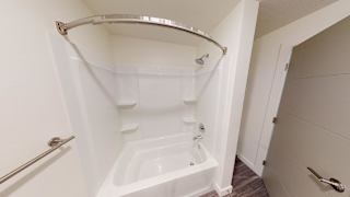 A white bathtub with a shower head and a grab bar. at Paperbox Lofts Apartments, Apartments, Salt Lake City  , UT