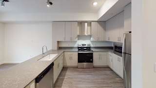 A modern kitchen with stainless steel appliances and white cabinets. at Paperbox Lofts Apartments, Utah, 84101