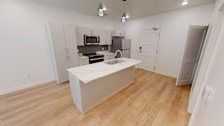 A kitchen with a white island in the middle of the room. at SevenO2 Main Apartments, Salt Lake City, UT, 84101