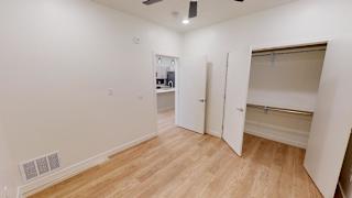 A room with wooden flooring and white walls, with a door open to another room. at SevenO2 Main Apartments, Salt Lake City, UT