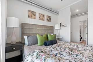 A bedroom with a floral bedspread and a headboard.