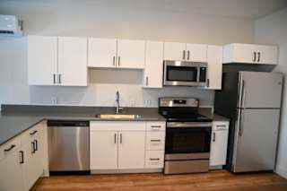Contemporary kitchen with stainless steel appliances and grey countertops at The Revival Apartments, Salt Lake City