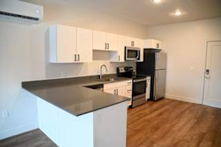 Kitchen with gray quartz countertops and peninsula at The Revival Apartments, Utah, 84101