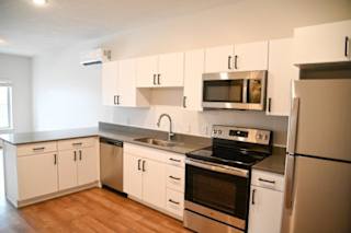 Contemporary kitchen with gray countertops and white cabinetry at The Revival Apartments, Salt Lake City, UT 84101