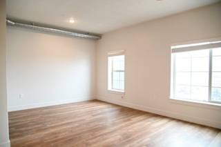 Empty bedroom with wood style flooring and windows at The Revival Apartments, Salt Lake City, Utah