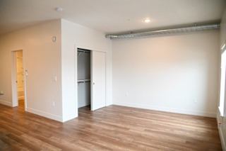 Empty bedroom with walk-in closet and wood flooring at The Revival Apartments, Salt Lake City