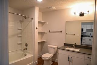 Bathroom vanity with dark countertop and built in shelves at The Revival Apartments, Salt Lake City, UT
