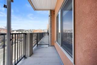 A balcony with a metal railing and a view of the city.