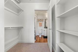 A white hallway with a toilet in the distance.