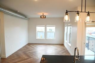 A room with a black counter and three hanging lights.