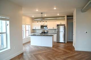 A kitchen with a refrigerator and a counter.