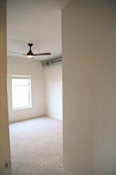 A room with a ceiling fan and a window.