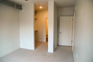 A room with a carpeted floor and a white door.
