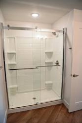 A white bathroom with a walk in shower.