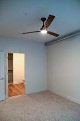 Empty bedroom with ceiling fan and carpeted floor at The Revival Apartments, Utah, 84101