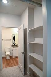 Builtin shelving closet with adjacent bathroom at The Revival Apartments, Utah