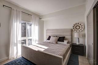 A bedroom with a large bed and a window with curtains. at Paperbox Lofts Apartments, Salt Lake City