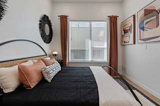 A bedroom with a large bed and two framed artworks on the wall.