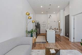 A modern living room with a grey sofa and a glass coffee table.