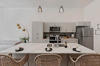 A modern kitchen with a dining table and chairs.