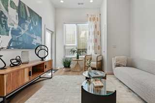 A living room with a glass coffee table and a couch.
