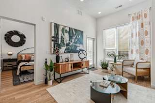 A modern living room with a large painting on the wall and a wreath on the door.