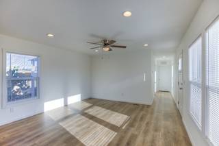A room with a ceiling fan and wooden flooring.