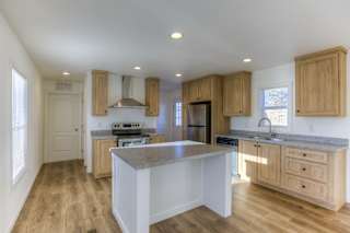 A kitchen with wooden cabinets and a marble countertop.