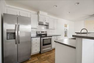 A modern kitchen with stainless steel appliances and white cabinetry.