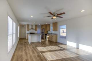 A spacious room with a ceiling fan and wooden flooring.