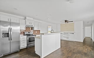 A modern kitchen with white cabinets and stainless steel appliances.