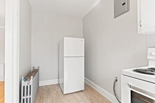 A white refrigerator is in a kitchen next to a white stove.