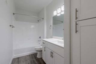 A white bathroom with a toilet, sink, and bathtub.