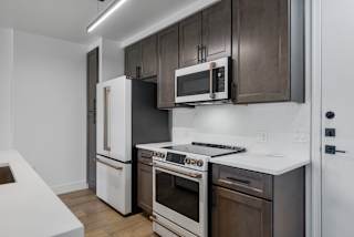 a kitchen with white appliances and dark wood cabinets