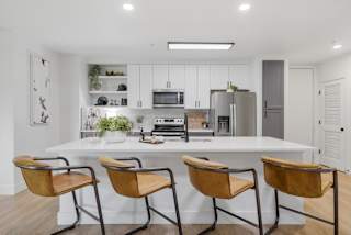 a kitchen with a large island and three chairs