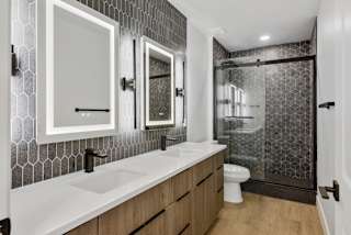 a bathroom with two sinks and a shower and a toilet