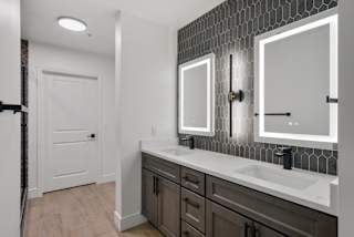 a bathroom with a sink and two mirrors