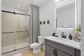 a bathroom with a shower and a sink and a toilet