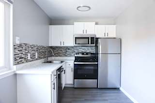 A modern kitchen with stainless steel appliances and white cabinets.