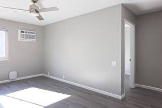 A room with a ceiling fan and a window.